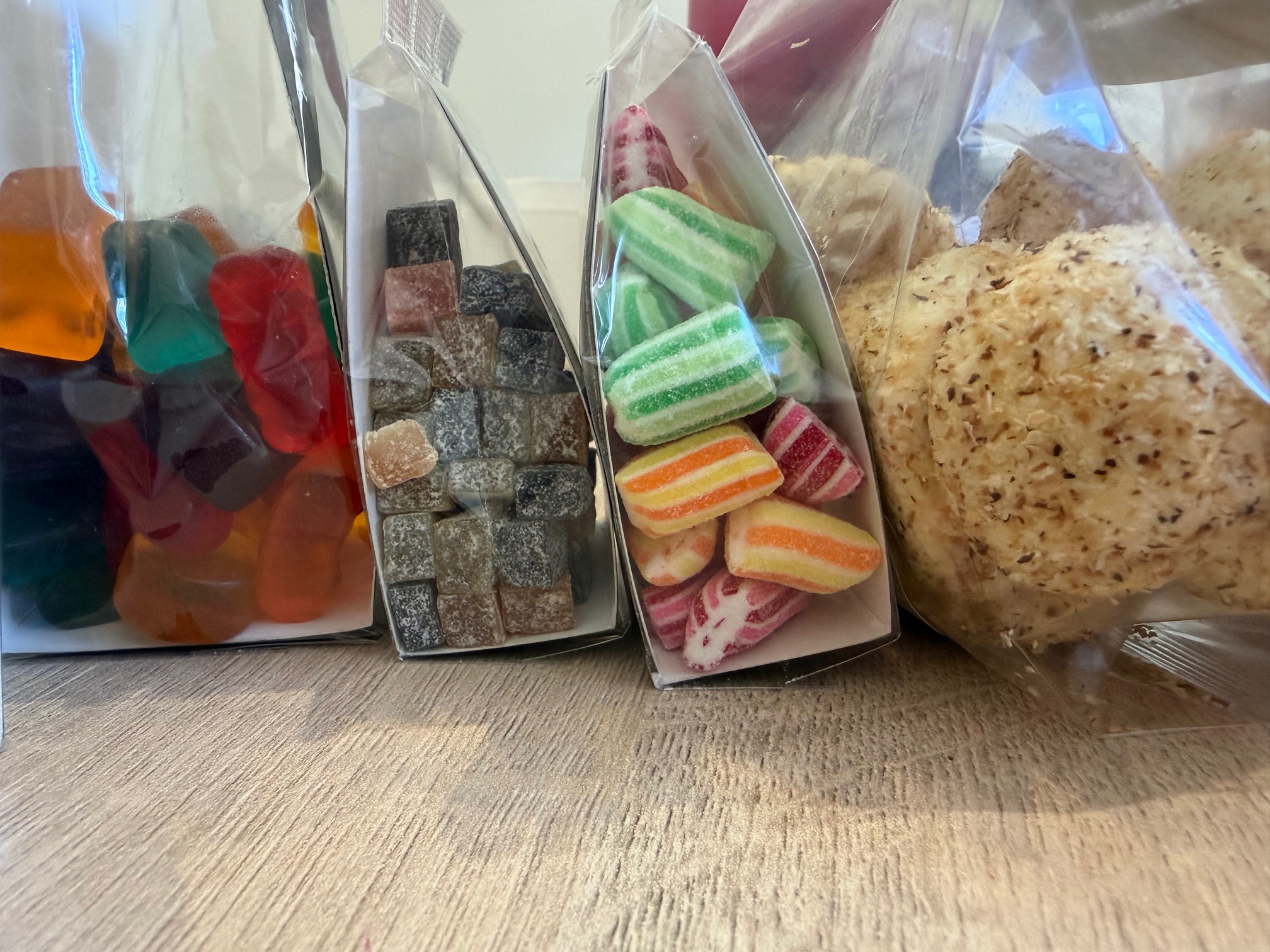 Fancy Inc branded treat range — gummy bears, dusted sweets, striped candy and coconut snowballs in clear packaging
