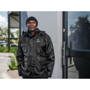 Branded winter workwear worn by a crew member on an early-morning industrial site