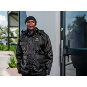 Branded winter workwear worn by a crew member on an early-morning industrial site