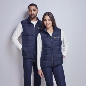 Retail staff member in a personal coat over a branded winter uniform shirt